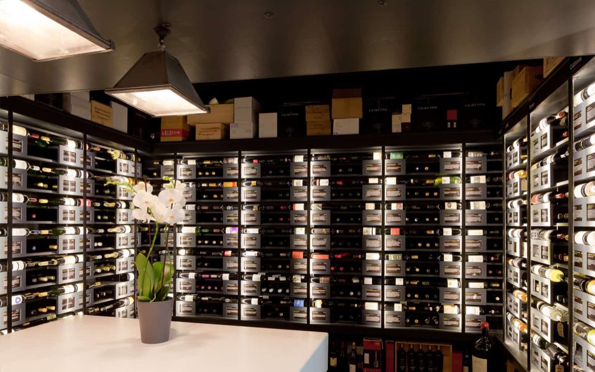 Oeno Wines customer selecting a bottle from bespoke lit display with back-lit information frames